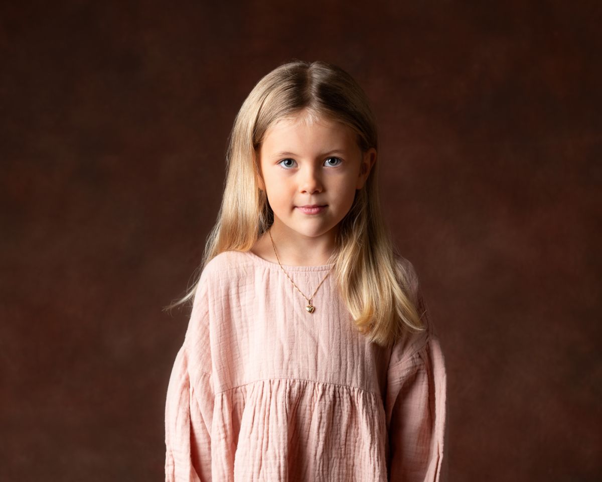 Barnfoto på en flicka mot mörk bakgrund