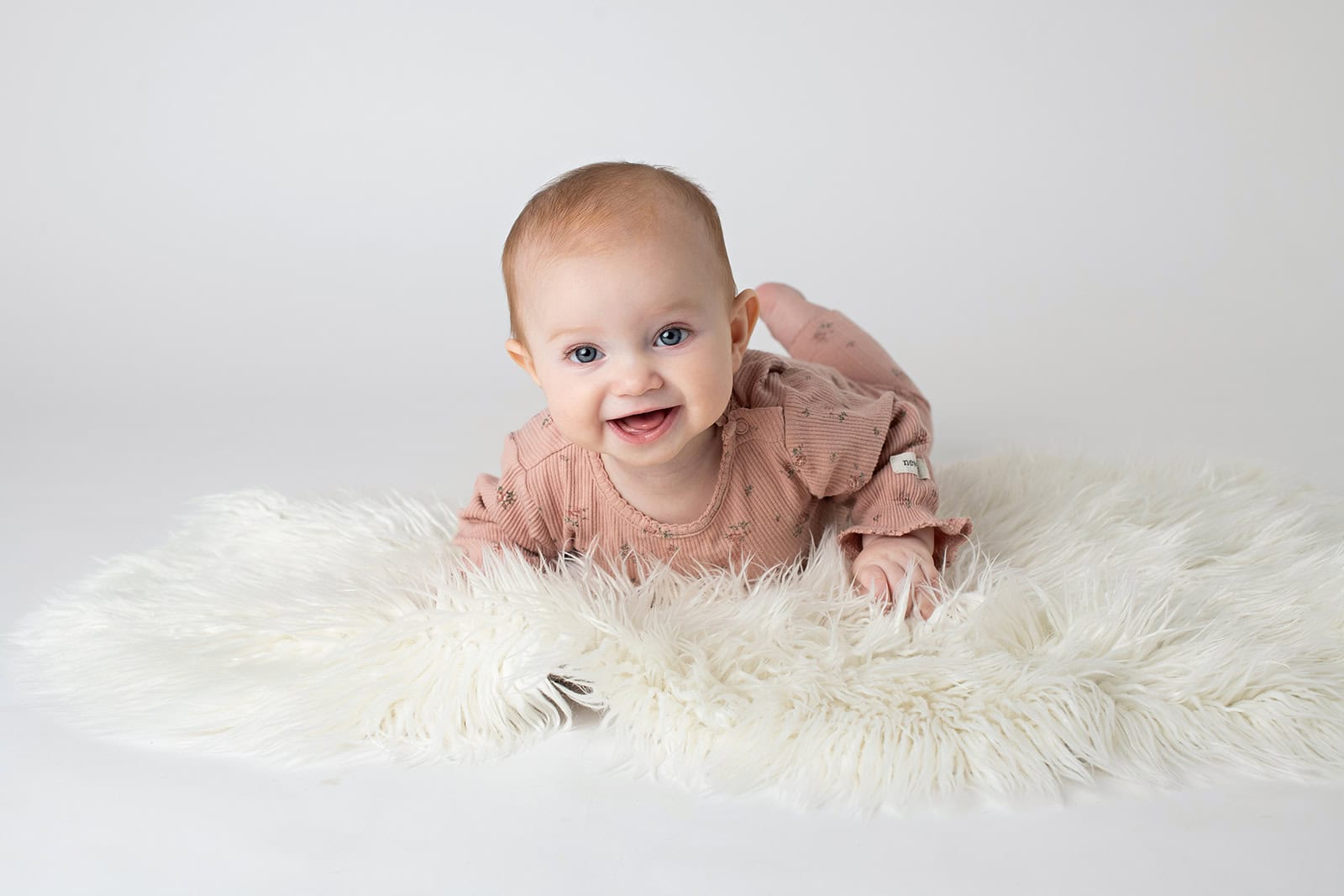 bebisfotograf lund med liten 7 månader tjej i vit studio