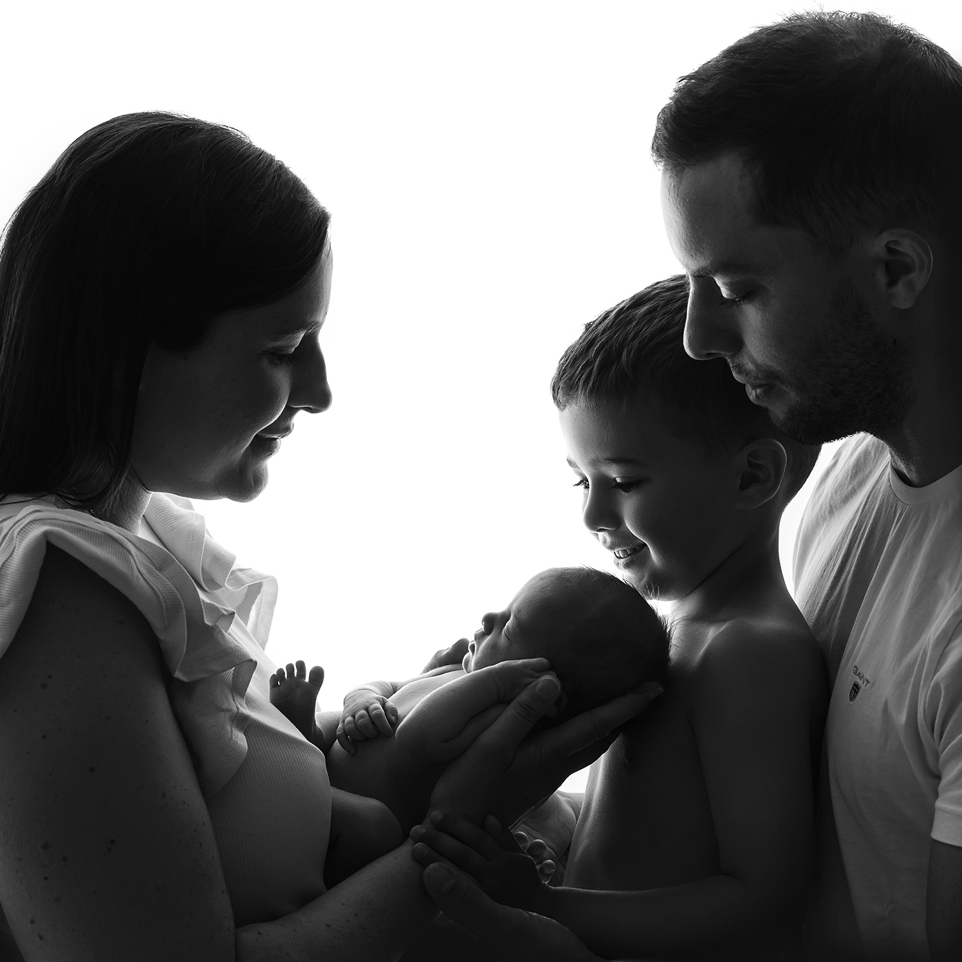 Nyföddfotografering med syskon och familj i siluett bild
